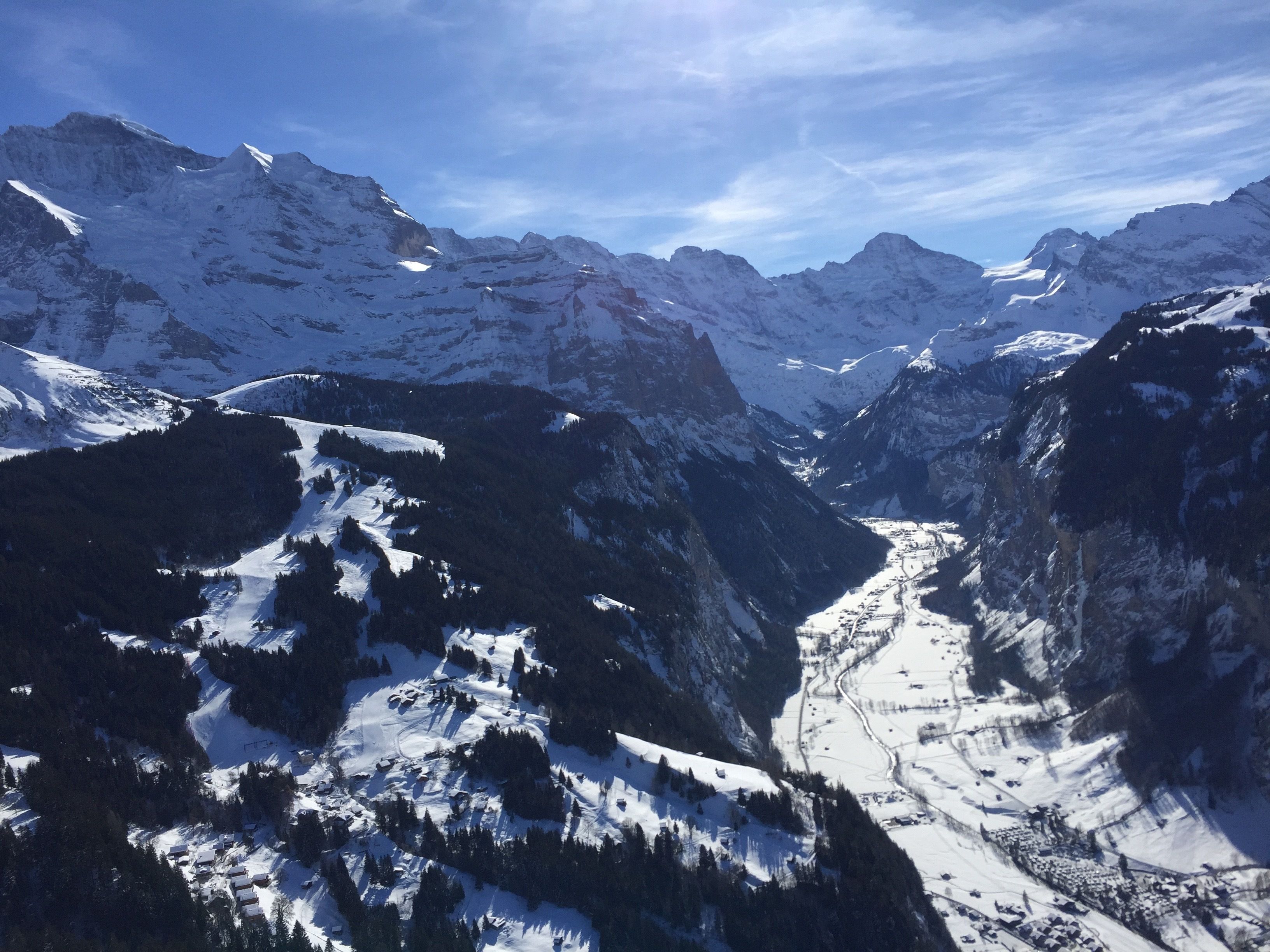 A mountainous landscape with snow-covered peaks and a valley.
