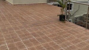 A building with a flat roof, a small balcony, and a tiled patio area. - FRF Hotel (Cap-Haitien)