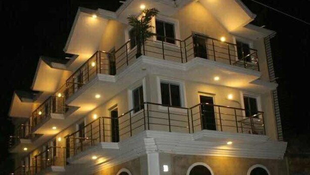 A multi-story hotel with balconies and arched windows. - FRF Hotel (Cap-Haitien)