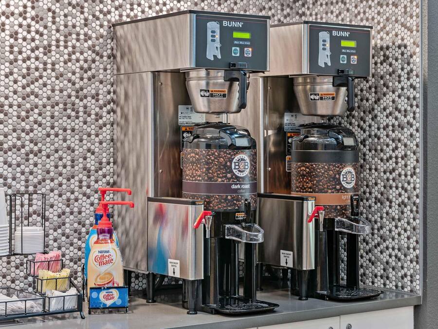 Twee Bunn koffieautomaten met een Nestlé Coffee Mate dispenser, een koffiemolen en een cafetière.