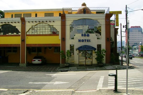 A hotel with a prominent sign reading "100 HOTEL" and "ECO HOTEL LOS PROCERES."