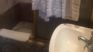 A bathroom with a sink, a mirror, and two towels hanging on a rack. - Eco Hotel Los Proceres (Guatemala City)