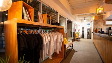 A clothing store with wooden shelves and racks of shirts.