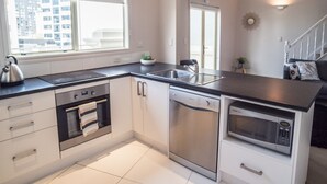 A modern kitchen with a built-in oven, dishwasher, and microwave. - U Suites on Manners (Wellington)