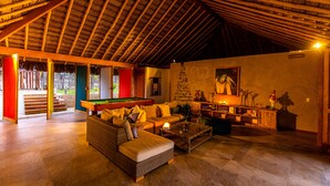 A spacious living area with a pool table, comfortable seating, and a cozy fireplace. - Casa Safran (Los Organos)