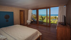 A bedroom with a bed, a TV, and a view of the ocean. - Casa Safran (Los Organos)