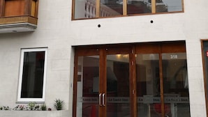 Un hôtel doté d’une grande entrée en verre, d’un balcon avec des balustrades en bois et d’une enseigne indiquant qu’il s’agit du Luna Inn.