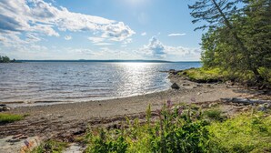Een natuurlandschap met water, een heldere lucht en begroeiing.