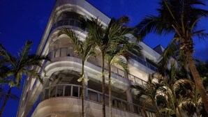 Un hôtel à plusieurs étages doté de balcons et de palmiers.