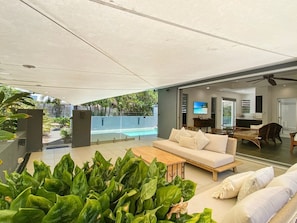 A modern living room with a sofa, coffee table, and plants.
