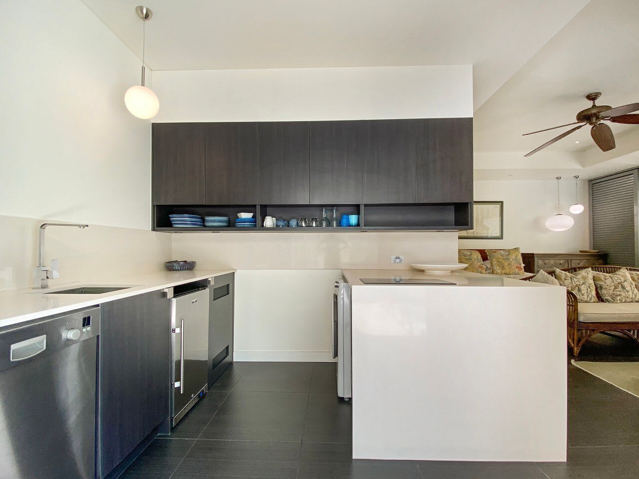 Una cocina moderna con electrodomésticos integrados, un comedor y un ventilador de techo.