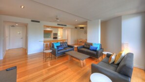 A spacious living room with a sofa, coffee table, and a dining area with chairs and a table.