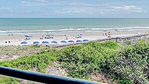 Uma praia com guarda-sóis e pessoas.