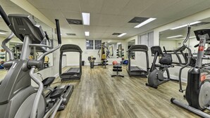 Ein Fitnessstudio mit Laufbändern, Crosstrainern und Gewichten.