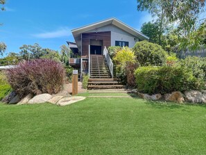 A modern two-story house with a front porch, a staircase leading to the entrance, and a well-maintained lawn. - Deb's Shed (Arcadia)