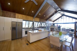 A modern kitchen with a central island, white cabinetry, and a large window.