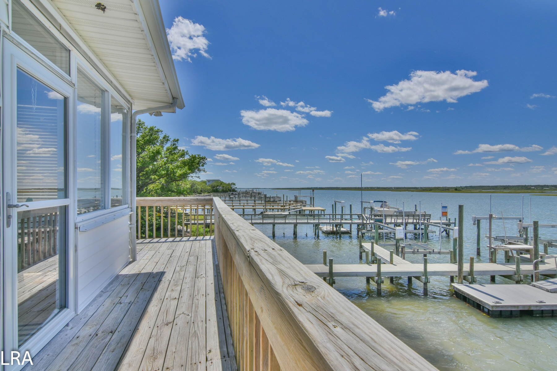 A wooden deck with a view of a marina and water.