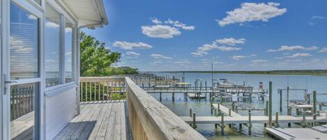A wooden deck with a view of a marina and water.