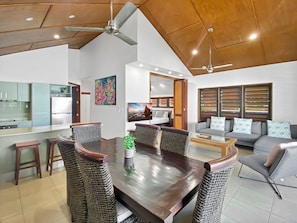 A modern interior with a dining area, kitchen, and living space. - Pure Magnetic Villa 9 (Nelly Bay)