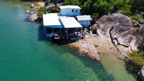A coastal property with a dock, a small building, and a large rock formation. - Blue on Cockle (Cockle Bay)