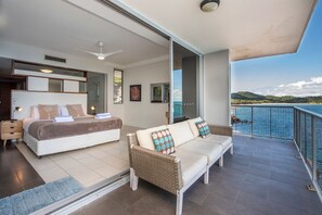 Ein Balkon mit Meerblick, ein Schlafzimmer mit Bett und Schlafsofa sowie ein Duschbereich.