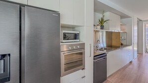 Una cocina moderna con electrodomésticos de acero inoxidable, microondas, horno y lavavajillas.