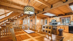 Un intérieur en bois comprenant un coin repas, une cuisine et un escalier.