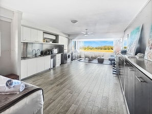 Eine moderne Küche mit Essbereich, Deckenventilator und Blick ins Freie.