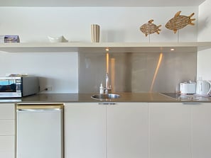 A modern kitchen with a stainless steel sink, a toaster, and a kettle.