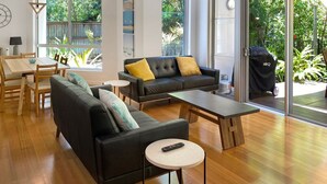 A modern living room with a sofa, coffee table, and dining area.