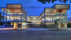 A multi-story hotel with a modern design, featuring balconies and large windows. - Maggies Beachfront Apt. 6 (Horseshoe Bay)