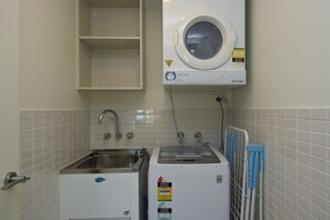 A laundry area with a washing machine, a dryer, and a sink.