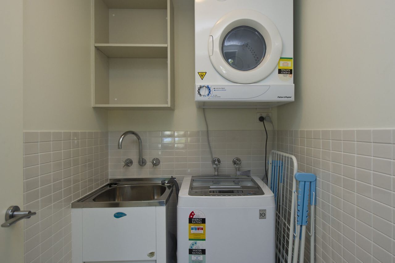 A laundry area with a washing machine, a dryer, and a sink.