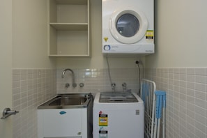Ein Waschraum mit Waschmaschine, Trockner und Spüle.