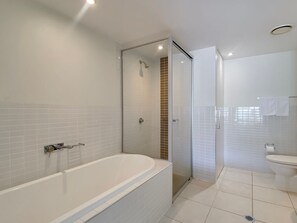 Ein modernes Badezimmer mit Badewanne, Dusche und Toilette.