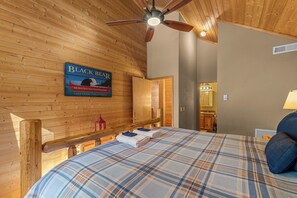 Innenansicht einer Holzhütte mit einem Bett, einem Deckenventilator und einem Schild für Black Bear Canoe Company.