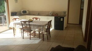 Un comedor con una mesa, sillas, microondas y refrigerador.