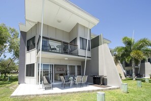 Un bâtiment moderne à deux étages, doté d’un balcon, d’un espace extérieur aménagé pour s’asseoir et d’un barbecue.