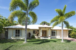 A two-story house with a front porch, a garage, and a well-maintained lawn.