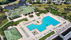 Oversigtsbillede af et hotel med en stor swimmingpool, flere opholdsområder og en parkeringsplads.
