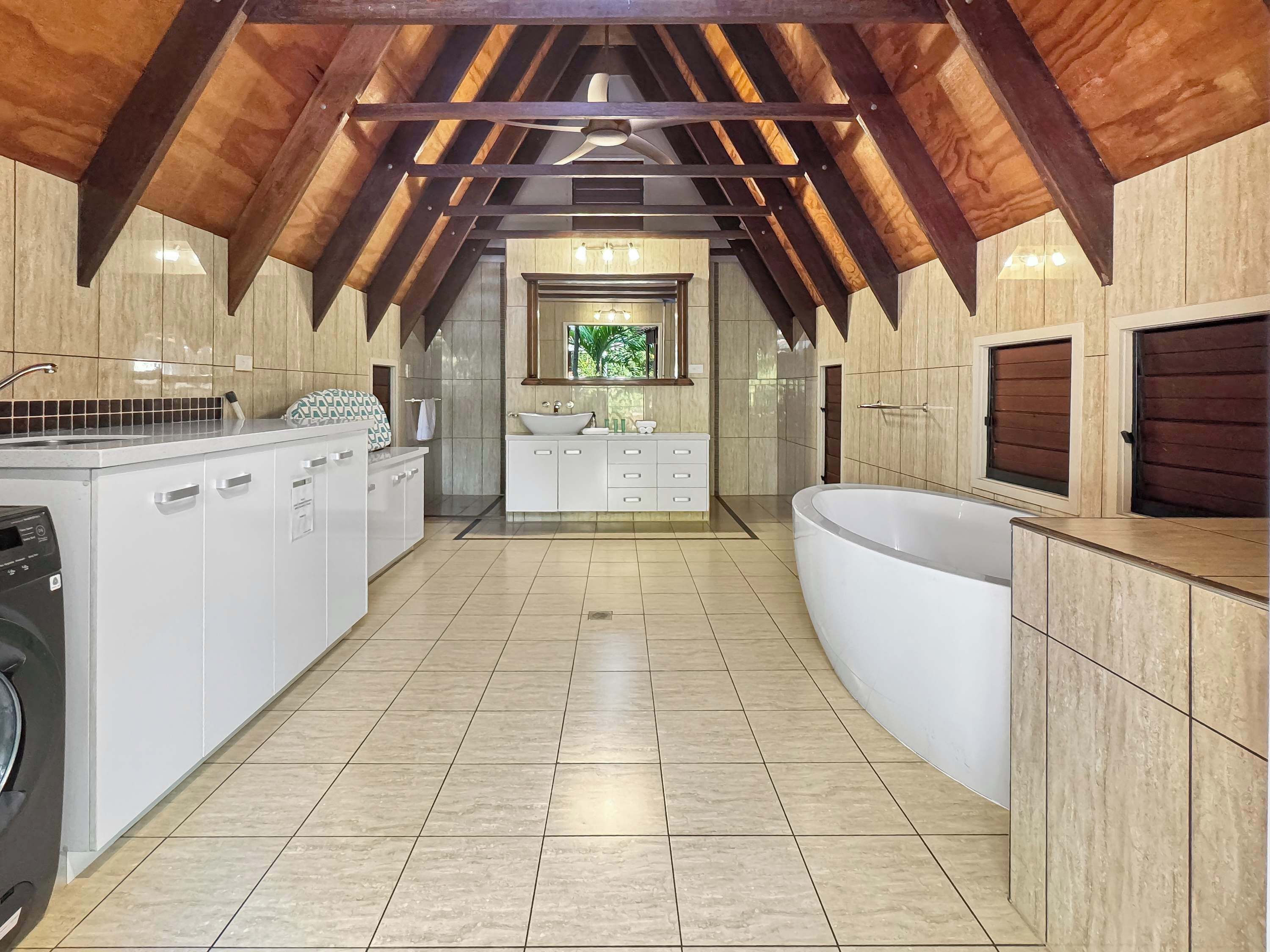 A modern kitchen with a built-in washing machine, a large sink, and a freestanding bathtub.