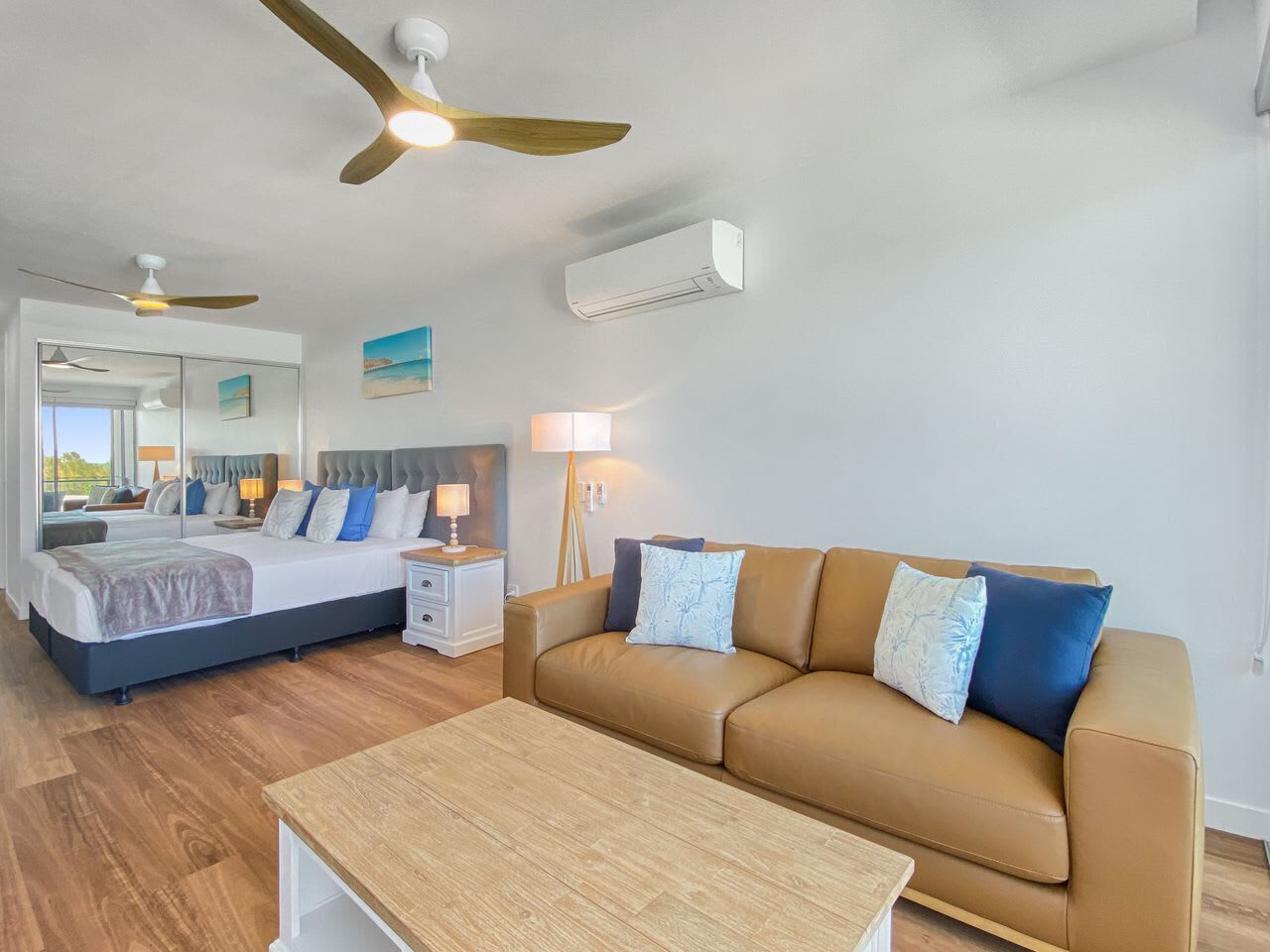 A bedroom with a bed, bedside tables, a nightstand, a sofa, and a coffee table.