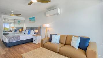 A bedroom with a bed, bedside tables, a nightstand, a sofa, and a coffee table.