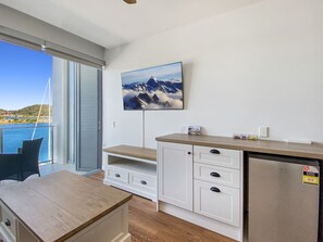A modern kitchen with a built-in refrigerator, wooden cabinets, and a large window overlooking a scenic view.