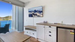 Eine moderne Küche mit integriertem Kühlschrank, Holzschränken und einem großen Fenster mit Blick auf eine schöne Landschaft.