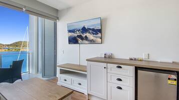 A modern kitchen with a built-in refrigerator, wooden cabinets, and a large window overlooking a scenic view.