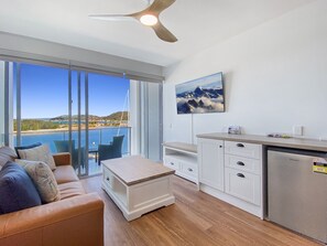 Ein modernes Wohnzimmer mit Sofa, Couchtisch und Meerblick.