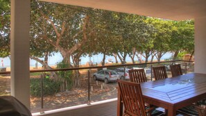 A balcony with a view of trees and parked cars. - Maggies Beachfront Apt. 3 (Horseshoe Bay)