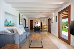 Relax in this stylish living area with a sofa, dining table, and balcony access.