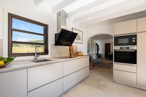 Enjoy a meal in the kitchen with an oven and microwave, and a seating area with a sofa and coffee table.